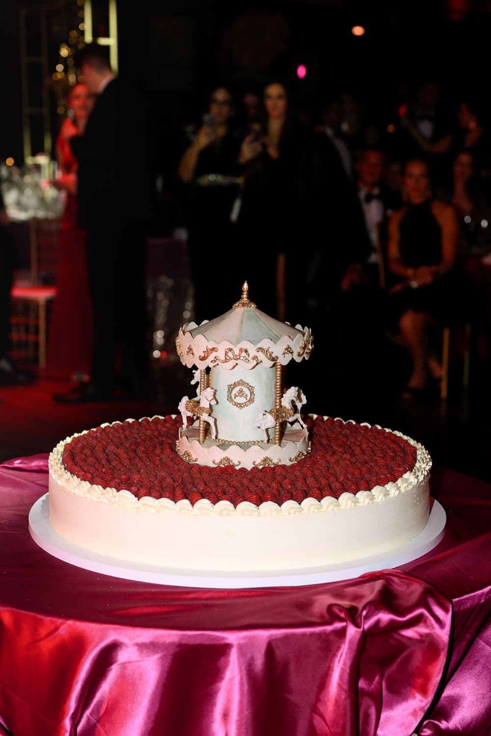 Mini körhintával díszített málnás torta a vendégek előtt