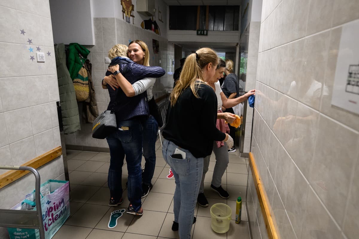 Önkéntesek és kórházi dolgozók ölelkeznek a felújítás közben